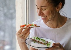 Woman smiling while eating healthy lunch