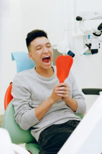 Man looking at his mouth in a dental mirror