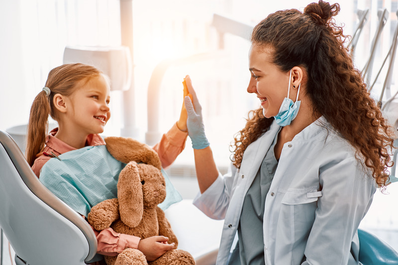 Family dentist giving child a high five